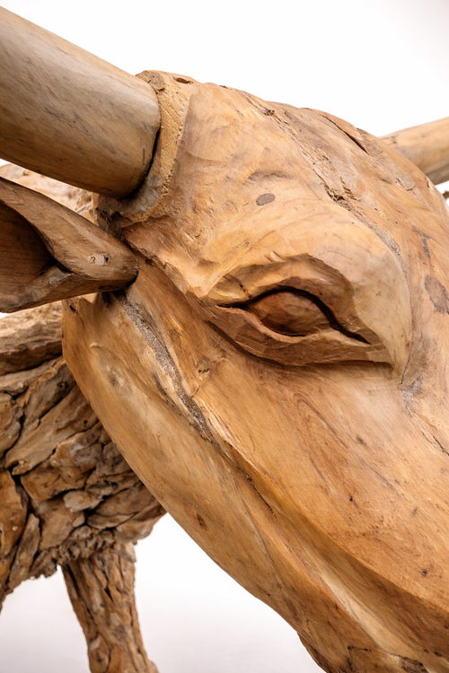 Close-up of a wooden sculpture of a bull's head with detailed features.